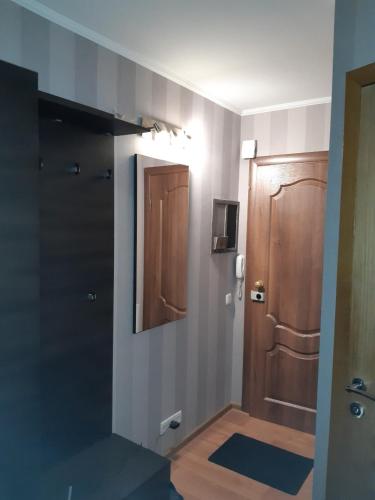 un bagno con porta in legno e una camera con pavimento di Аппартаменты на Бутырина a Kremenčuk