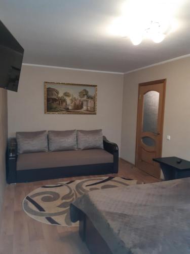 uma sala de estar com um sofá e uma mesa em Аппартаменты на Бутырина em Kremenchuk