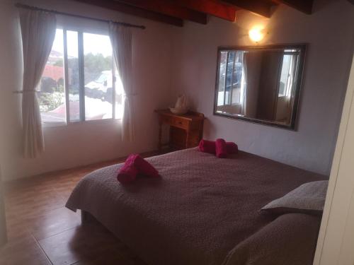 1 dormitorio con 1 cama con 2 almohadas rojas en Casita De Gato, en Tahiche