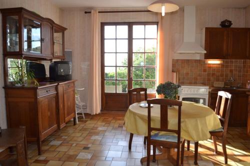 une cuisine avec une table et un chiffon de table jaune dans l'établissement la hulotte, à Plougastel-Daoulas