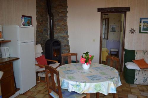 une cuisine avec une table avec un vase de fleurs dessus dans l'établissement la hulotte, à Plougastel-Daoulas