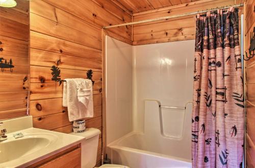 a bathroom with a toilet and a tub and a sink at Expansive Gatlinburg Cabin Hot Tub, Deck and Grill! in Gatlinburg