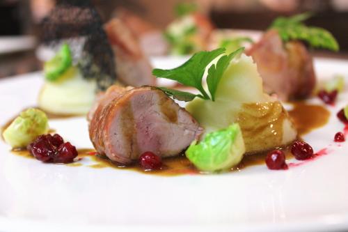 a white plate of food with meat and vegetables at Villa Patriot Boutique Hotel in Mariánské Lázně