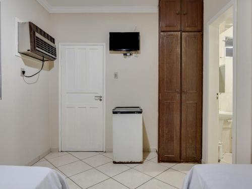 a white room with a door and a trash can at Hotel Estrela Do Vale in Ipatinga