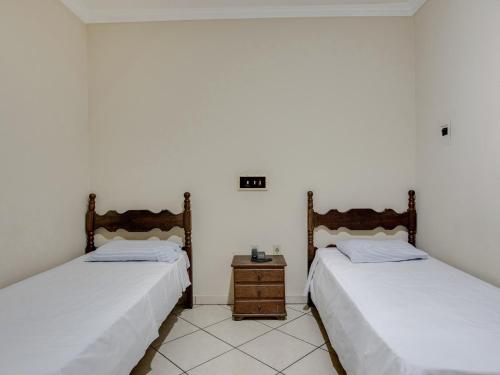 two beds sitting next to each other in a room at Hotel Estrela Do Vale in Ipatinga