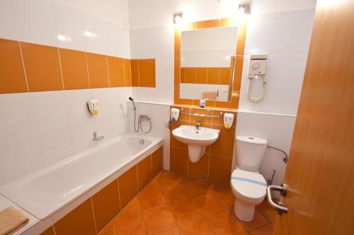a bathroom with a tub and a toilet and a sink at Hotel Blue Bratislava in Bratislava
