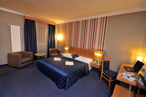 a hotel room with a bed and a desk and chair at Hotel Blue Bratislava in Bratislava