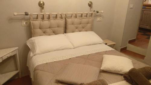 a bed with white sheets and pillows in a room at Casa Quaratica in Riccò del Golfo di Spezia