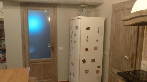 a white refrigerator in a kitchen with magnets on it at Casa Quaratica in Riccò del Golfo di Spezia