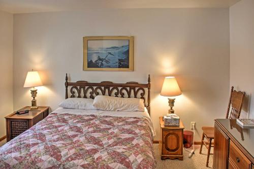 een slaapkamer met een bed en twee tafels en twee lampen bij Cozy Balsam Lake Home Deck, Private Dock and Kayaks in Balsam Lake