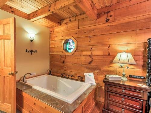 a bath tub in a room with wooden walls at Cozy Nest Gatlinburg Cabin with Porch and Jacuzzi! in Gatlinburg