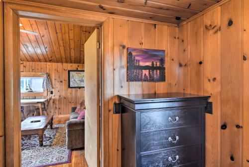 a room with a black dresser in a cabin at Lovely Lake Huron Getaway Beach Access and Kayaks! in Evergreen Shores