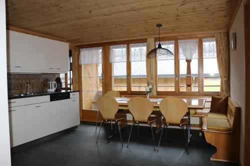 eine Küche mit einem Tisch und Stühlen im Zimmer in der Unterkunft Bühlerhof in Lenk im Simmental