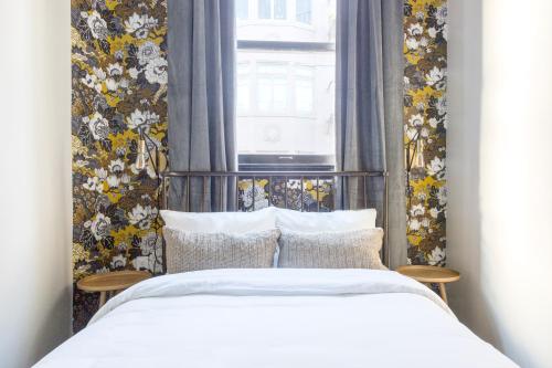 舊金山的住宿－Sonder Hayes Valley，一间卧室设有床铺和一个带花卉壁纸的窗户。