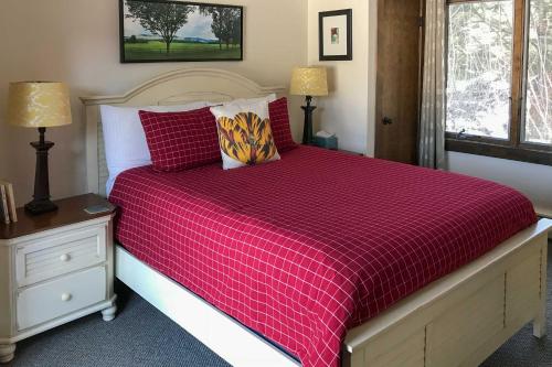 1 dormitorio con 1 cama grande y edredón rojo en Stowe Vacation Rental with Deck and Mountain Views!, en Stowe