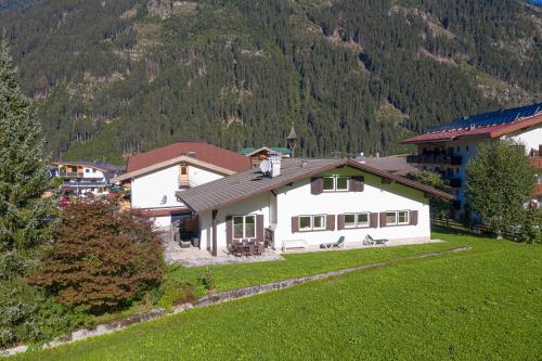 a white house with a mountain in the background at Ahorn Chalet in Mayrhofen