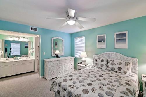 a bedroom with a bed and a bathroom with a ceiling fan at Beachfront Cedar Key Condo with Pool, Spa and Views! in Cedar Key