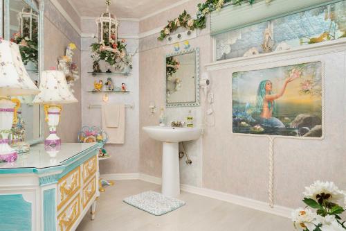 een badkamer met een wastafel en een schilderij aan de muur bij Pams Mermaid House with Riverfront Yard and Lanai! in Weeki Wachee