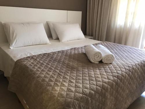 a bedroom with a bed with two towels on it at Caravaggio Praia Hotel in Florianópolis