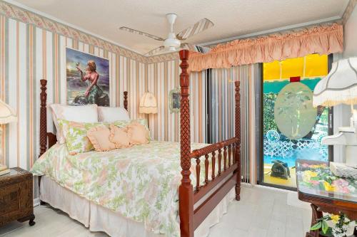 a bedroom with a bed and a painting on the wall at Pams Mermaid House with Riverfront Yard and Lanai! in Weeki Wachee