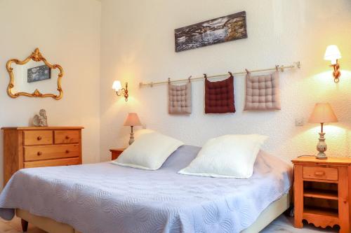 a bedroom with a bed and two lamps and a mirror at La Grande Eperviere in Barcelonnette