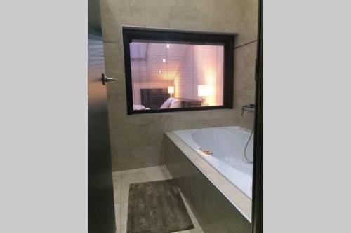 a bathroom with a bath tub and a mirror at Ioannina Luxury Suites & Apartments in Ioannina