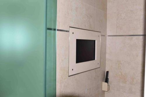 a small television on a wall in a bathroom at Ioannina Luxury Suites & Apartments in Ioannina