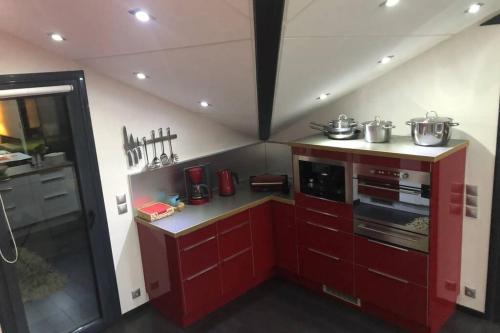 a small kitchen with red cabinets and a stove at Ioannina Luxury Suites & Apartments in Ioannina