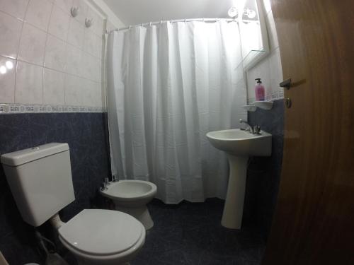 een badkamer met een wit toilet en een wastafel bij Torres del Centro - Av Colón esq Gral paz in Cordoba