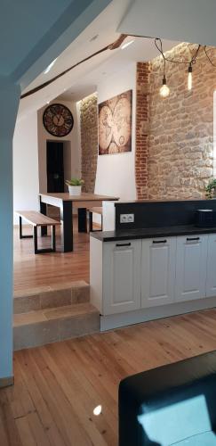 une cuisine avec des placards blancs et un mur en briques dans l'établissement Atypical Flat, à Charleville-Mézières