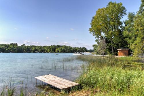 a wooden bench sitting on the shore of a lake at Waupaca Lakefront Home with Pool Table and Dock! in Waupaca