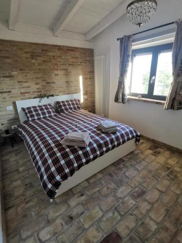 a bedroom with a bed and a brick wall at Il Melograno House in Pollutri