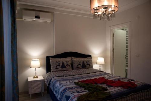 a bedroom with a bed and two lamps and a chandelier at Nupelda Residence Hotel in Istanbul