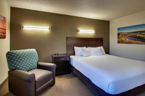 a hotel room with a bed and a chair at EverSpring Inn in Bismarck