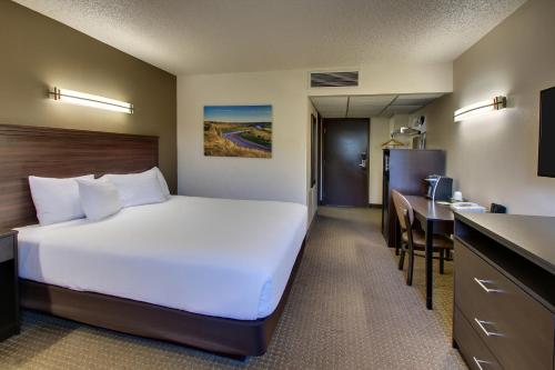 a hotel room with a large bed and a desk at EverSpring Inn in Bismarck