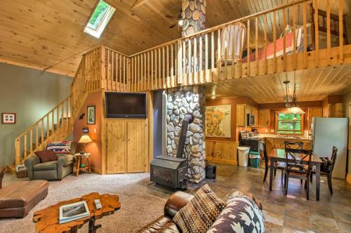 a living room with a fireplace in a log cabin at Trout Lake Cabin with Private Dock, Kayaks and Loft! in Grand Rapids