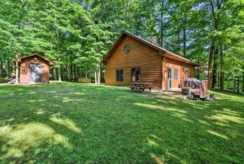 a log cabin in the middle of a yard at Trout Lake Cabin with Private Dock, Kayaks and Loft! in Grand Rapids