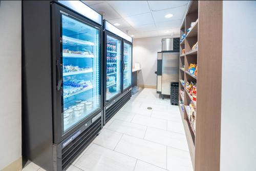 a store aisle with a large refrigerator at Holiday Inn Express Rochelle by IHG in Rochelle