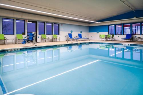 uma grande piscina com cadeiras e mesas em Holiday Inn Express Rochelle, an IHG Hotel em Rochelle