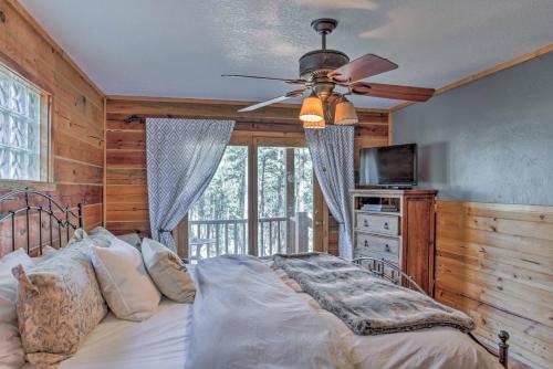 una camera da letto con un letto e un ventilatore a soffitto di Ruidoso Log Cabin Retreat - Peaceful and Convenient a Ruidoso