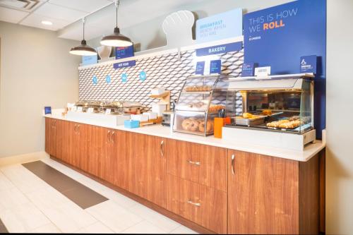 a bakery counter with wooden cabinets and donuts at Holiday Inn Express Rochelle by IHG in Rochelle