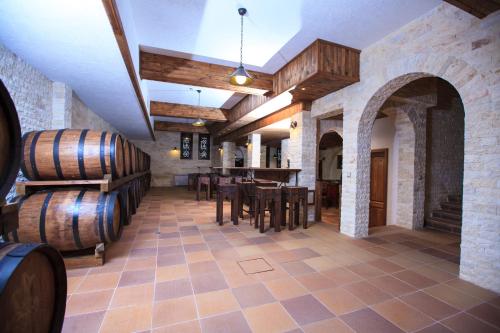 a wine tasting room with a table and wine barrels at Zlaten Rozhen Family Hotel- Monument of Cultural Significance in Rozhen