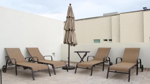 a group of chairs and a table with an umbrella at Holiday Inn Express Puerto Vallarta by IHG in Puerto Vallarta