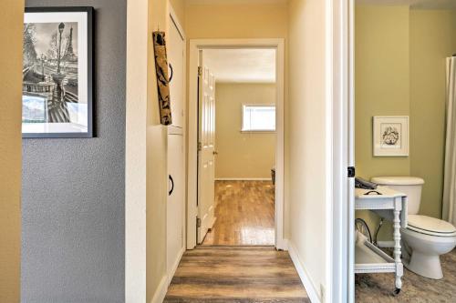 a hallway of a bathroom with a toilet and a sink at Waterfront Osoyoos Lake Cottage with Beach and Patio! in Oroville