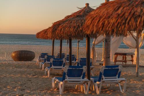 a group of chairs and umbrellas on a beach at Grand Decameron Los Cabos, A Trademark All-Inclusive Resort in San José del Cabo