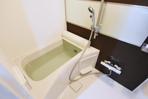 a bathroom with a bath tub and a toilet at Tune Inn Ebisu in Tokyo
