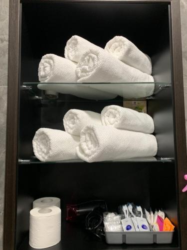 - une étagère avec des serviettes et des articles de toilette dans la salle de bains dans l'établissement Fountain Appartement, à Lviv