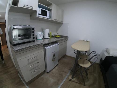 cocina pequeña con microondas y fogones en Departamento Aires Verdes de Salta en Salta