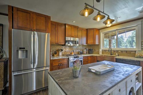 a kitchen with a stainless steel refrigerator and wooden cabinets at Home with Jacuzzi 10 Mi to NAU and Flagstaff! in Mountainaire