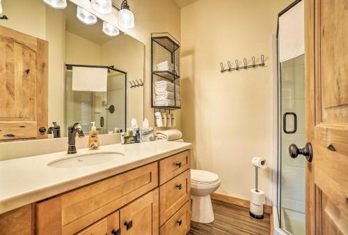 ein Badezimmer mit einem Waschbecken, einem WC und einem Spiegel in der Unterkunft Soldotna Fishing Cabin about Half-Mi to Kenai River! in Soldotna